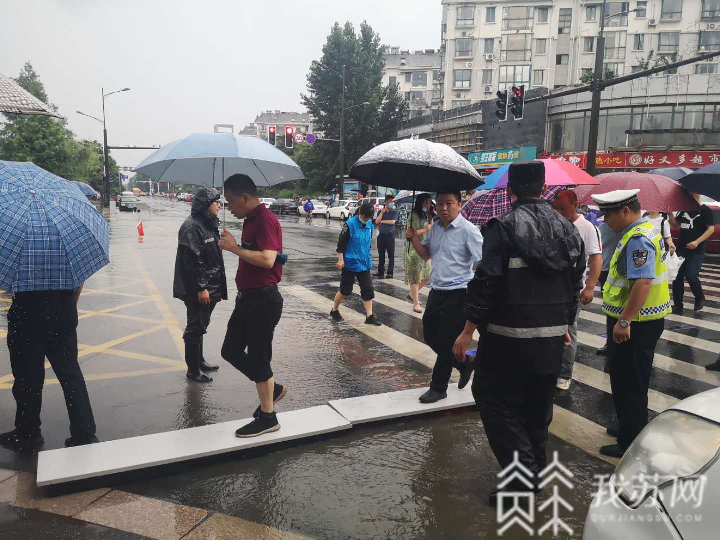 考生■大雨也浇不灭心中火热，为了高考考生城管遇水搭桥
